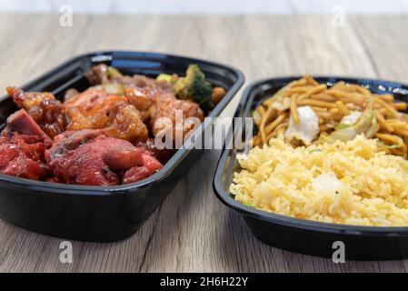Pasto cinese a base di fast food con riso fritto, chow mein, pollo e costolette di ricambio per barbecue per un pasto molto abbondante. Foto Stock