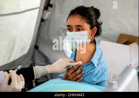 Kathmandu, Nepal. 15 Nov 2021. Una giovane ragazza prende il suo primo jab di vaccino Pfizer-BioNTech all'ospedale civile. Il governo nepalese ha iniziato ad inoculare i bambini di età superiore ai 17 anni e le persone malate cronicamente con il vaccino Pfizer fornito dal governo degli Stati Uniti al Nepal attraverso il COVAX Facility. Credit: SOPA Images Limited/Alamy Live News Foto Stock