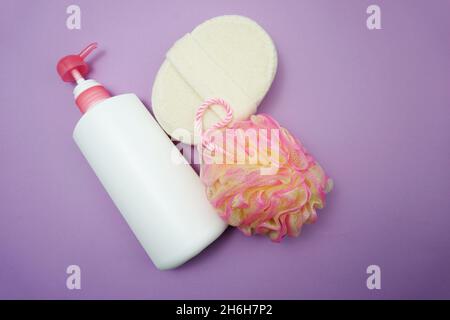 Prodotti da bagno a fondo piatto doccia bottiglia con soffio doccia e spazzola per capelli su sfondo viola Foto Stock