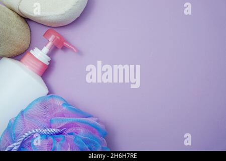 Prodotti da bagno a fondo piatto doccia bottiglia con soffio doccia e spazzola per capelli su sfondo viola Foto Stock