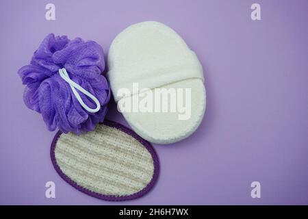 Prodotti da bagno a fondo piatto doccia bottiglia con soffio doccia e spazzola per capelli su sfondo viola Foto Stock