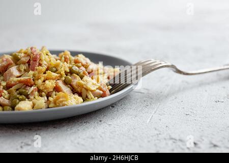 Riso tradizionale cantonese o cinese fritto fatto in casa da vicino al tavolo grigio Foto Stock