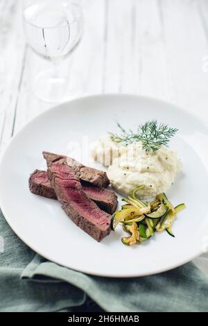 Bistecca di manzo alla purea di cavolfiore con verdure zucchine (carb basso) Foto Stock