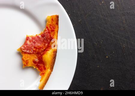 Pizza mangiata a metà. Piastra sporca. Avanzi. Pizza amaro. Foto Stock