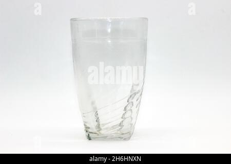 Bicchiere di vetro isolato su sfondo bianco con messa a fuoco selettiva Foto Stock