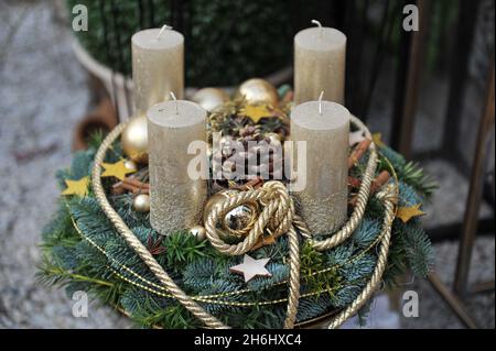 Decorazioni natalizie all'interno. Una corona di avvento con quattro candele dorate Foto Stock