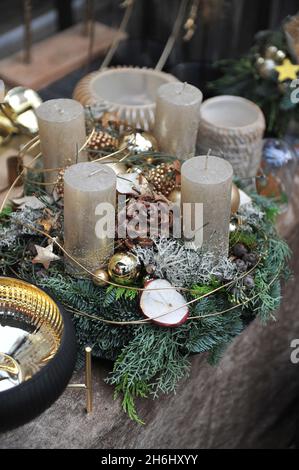 Decorazioni natalizie all'interno. Una corona di avvento con quattro candele dorate Foto Stock