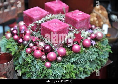 Decorazioni natalizie all'interno. Una corona di avvento con quattro candele rosa Foto Stock