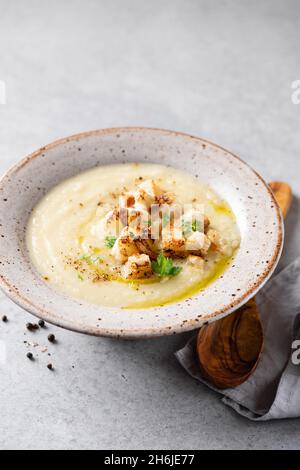 Zuppa di crema di cavolfiore vegano con crostini di pane su sfondo grigio tavolo in cemento, spazio copia Foto Stock