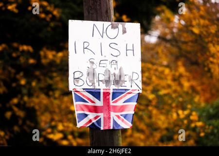 Cartello anti-frontiera del Mare d'Irlanda e piccola bandiera dell'Unione attaccata a un lampione a Bangor, Irlanda del Nord, in opposizione al protocollo dell'Irlanda del Nord. Foto Stock