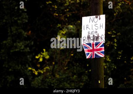 Cartello anti-frontiera del Mare d'Irlanda e piccola bandiera dell'Unione attaccata a un lampione a Bangor, Irlanda del Nord, in opposizione al protocollo dell'Irlanda del Nord. Foto Stock