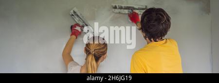 Un uomo e una donna stanno intonacando le pareti della casa. Banner fai da te per la ristrutturazione della casa, FORMATO LUNGO Foto Stock