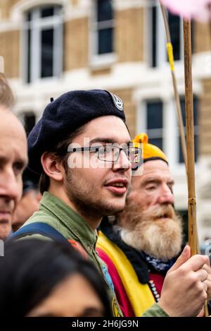 Giovane e vecchio protestore che porta insieme una bandiera, Rise and Rebel march, Extinction Rebellion, Londra, Regno Unito. 13 novembre 2021 Foto Stock