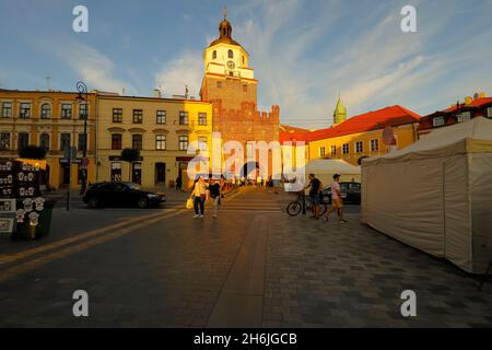 Lublino, Polonia - 10 settembre 2021: Al crepuscolo, la gente cammina lungo l'ampio percorso pedonale verso la famosa porta di Cracovia che conduce alla città vecchia. Foto Stock