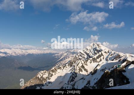 Territorio di Sochi Krasnodar il 29 2018 aprile. Montagne innevate nelle nuvole. Catena montuosa caucasica a Krasnaya Polyana, località sciistica di Rosa Khutor. Foto Stock