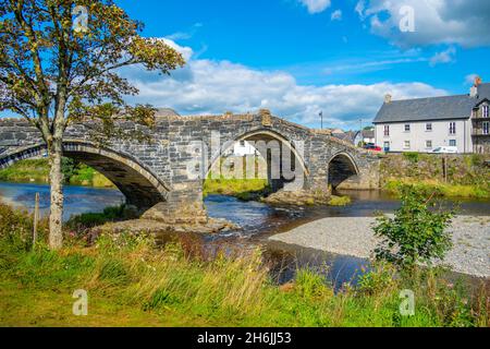 Vista di Pont Fawr (Inigo Jones Bridge) sul fiume Conwy e le case lungo il fiume, Llanrwst, Clwyd, Snowdonia, Galles del Nord, Regno Unito, Europa Foto Stock