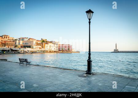 Vecchia lanterna nel porto veneziano di Chania con faro sullo sfondo, Creta, Isole greche, Grecia, Europa Foto Stock