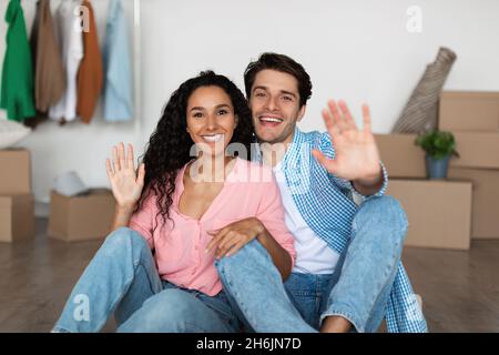 La coppia felice agitava le mani alla macchina fotografica per celebrare il giorno in movimento Foto Stock
