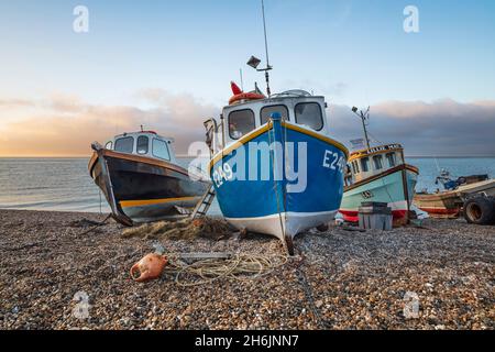 Barche da pesca tirate su sulla spiaggia di ghiaia all'alba, birra, Jurassic Coast, Devon, Inghilterra, Regno Unito, Europa Foto Stock