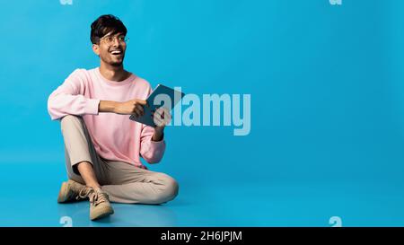 Elegante uomo indù con tablet digitale che guarda lo spazio di copia Foto Stock