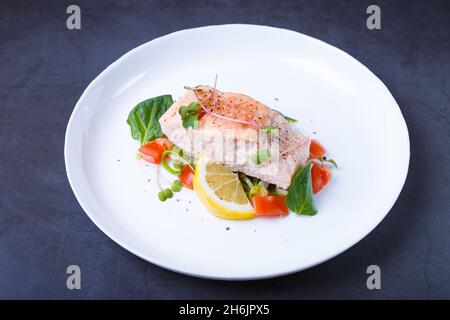 Trota (salmone) con verdure, limone e micrograni, cotti con il metodo confit. Piatto francese tradizionale. Passo dopo passo. Primo piano. Foto Stock