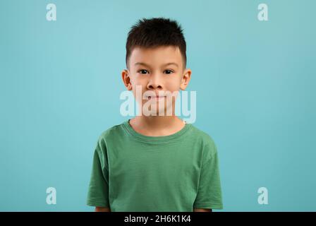 Ritratto figlio. Primo piano Shot di carino piccolo asiatico ragazzo guardando la fotocamera Foto Stock