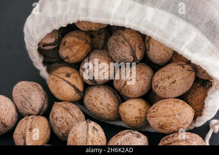 Noci in sacchetto di tessuto su sfondo nero. Primo piano Foto Stock