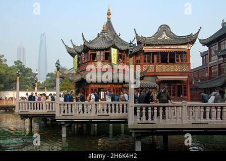 Shanghai, Cina: Il Teahouse Huxinting nella città vecchia di Shanghai. La gente cammina attraverso il ponte zig-zag sopra un piccolo lago vicino ai Giardini Yu. Foto Stock