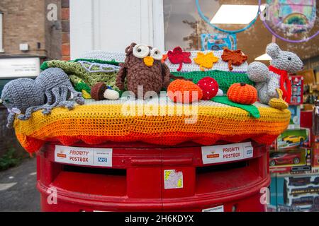 Farnham Common, 28 ottobre 2021. Un vivace autunno Halloween in maglia post box topper esposizione in Farnham Common. Cappelli a maglia per le scatole postali Royal Mail sono stati apparsi in tutto il paese portando allegria e felicità alle comunità locali. I loro creatori rimangono anonimi. Credit: Maureen McLean/Alamy Foto Stock