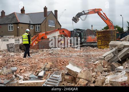 Cippenham, Slough, Berkshire, Regno Unito. 28 ottobre 2021. Un ex edificio per uffici e manutenzione auto in corso di demolizione sulla A4 a Cippenham in Slough. Il governo sta promuovendo il piano di sviluppo "Build Back Better" per la crescita in seguito alla pandemia del Covid-19. Molti edifici che vengono demoliti intorno Slough hanno nuovi appartamenti residenziali ad alta densità costruiti sui lotti con parcheggio molto limitato nella teoria che la gente userà la nuova linea di Elizabeth di Crossrail una volta che finalmente entra in funzione. Credit: Maureen McLean/Alamy Foto Stock