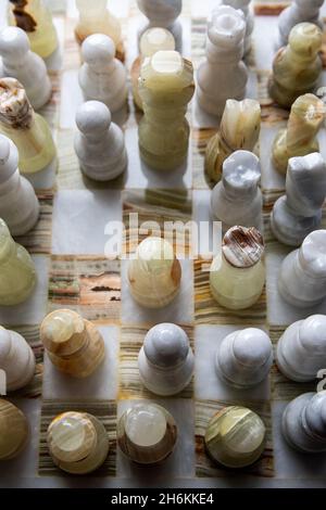 Primo piano verticale di scacchi bianchi e beige sulla scacchiera Foto Stock