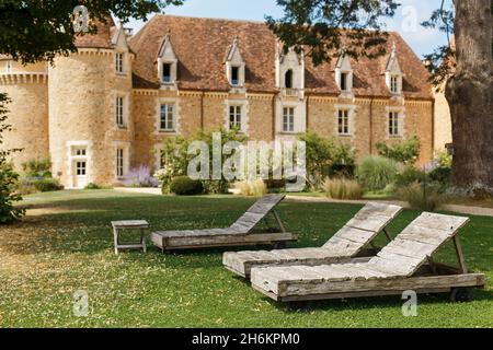 Bordeaux, Francia - 2019: Lettini in legno sullo sfondo del vecchio castello. Luogo di lusso per il riposo e il trattamento. Sedie per il relax Foto Stock