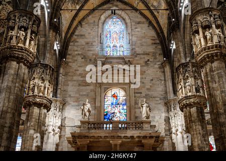 Vetrata con la Vergine Maria sopra il balcone con statue nel Duomo. Italia, Milano Foto Stock