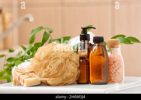 Saponette, spugna da bagno e bottiglie di prodotti cosmetici su tavola Foto Stock