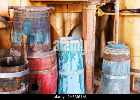 Primo piano di botti d'antiquariato, secchio d'acqua, e buccia di burro. Foto Stock