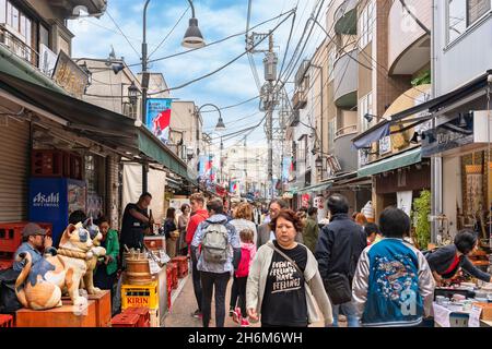 tokyo, giappone - ottobre 24 2021: La folla passeggiando lungo l'iconico paio di due statue in legno a bocca aperta e chiusa di gatti maneki-neko giapponesi con Foto Stock