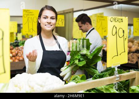 negozio persone in piedi vicino cavolo in drogheria Foto Stock