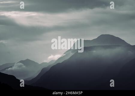 Silhouette di montagna. Nubi dalle silhouette montane a strati monocromatiche fumanti Foto Stock