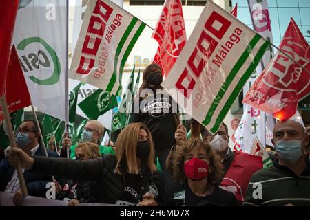 Malaga, Spagna. 16 novembre 2021. I manifestanti ondano bandiere durante una protesta contro il licenziamento dei dipendenti della banca Unicaja, di fronte alla sede centrale di Unicaja.la banca spagnola Unicaja ha proposto un piano di licenziamento di oltre 1,500 dipendenti. I principali sindacati hanno lanciato numerose proteste e scioperi contro il massiccio licenziamento di dipendenti dopo che i profitti milionari sono stati vinti con la fusione tra Unicaja e Liberbank. Credit: SOPA Images Limited/Alamy Live News Foto Stock