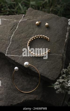 Vista dall'alto di bracciali e orecchini dal design moderno a tema naturale Foto Stock