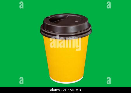 Caffè o tazzina di carta gialla. Tazza di cartone su sfondo verde isolato Foto Stock