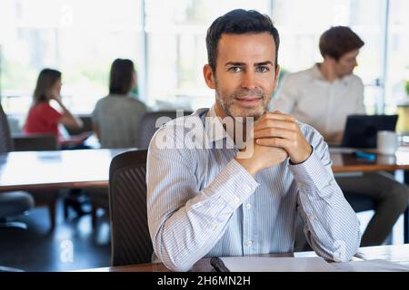 Ritratto di uomo maturo seduto alla scrivania in ufficio Foto Stock