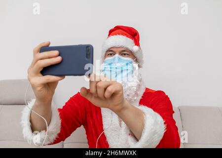 Vestito come Babbo Natale che parla tramite videoconferenza Foto Stock