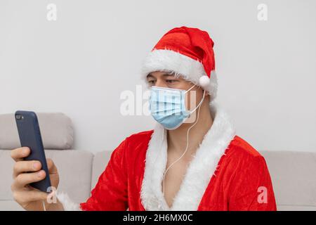 Vestito come Babbo Natale che parla tramite videoconferenza Foto Stock