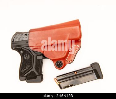 Una pistola semiautomatica Ruger LCP II a 10 colpi di calibro .22 LR in una custodia in pelle con caricatore aggiuntivo isolato su bianco. Foto Stock