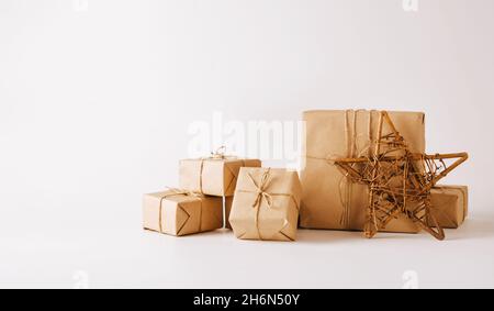 Stella fatta a mano, regali in carta semplice imballaggio sfondo chiaro. Composizione festiva per Natale o Capodanno Foto Stock