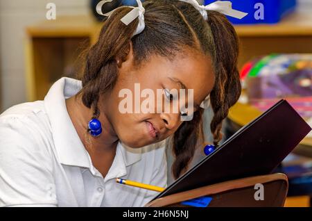 Una studentessa della scuola elementare si concentra mentre lavora su una lezione, il 30 marzo 2012, a Columbus, Mississippi. Foto Stock