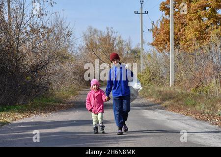 Verkhnotoretske, Ucraina. 16 ottobre 2021. I bambini hanno visto camminare lungo la strada con la legna alla periferia del villaggio.Verkhnotoretske è una città Ucraina situata vicino alla linea di fronte nel distretto di Yasynuvata nell'oblast di Donetsk, Ucraina orientale. Durante la guerra di Donbas, iniziata a metà aprile 2014, la linea di divisione tra le parti in guerra si trovava nelle vicinanze dell'insediamento. Il villaggio era una zona grigia fino alla fine del 2017. Oggi Verkhnotoretske è territorio ucraino. (Foto di Andriy Andriyenko/SOPA Images/Sipa USA) Credit: Sipa USA/Alamy Live News Foto Stock