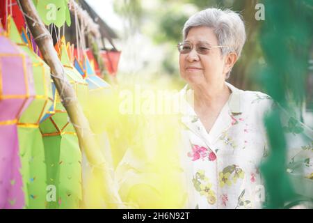 anziano anziano asiatico con appendere carta decorativa festiva lanterna Foto Stock