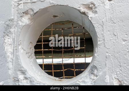 Un foro rotondo in mattone intonacato muro coperto di filo per impedire l'entrata in capanna costruita dagli Americani per osservazione durante la guerra mondiale 2, Townsville, Qu Foto Stock